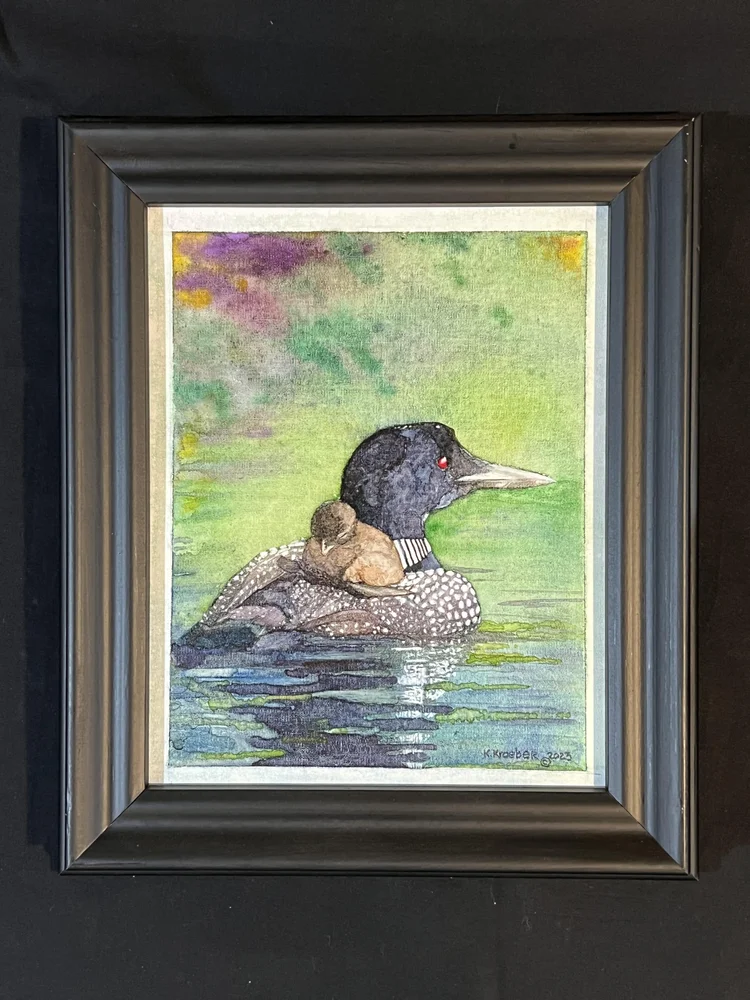 Watercolor painting of a loon carrying a chick on its back.
