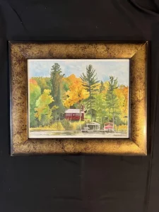 Red Cabin on Big Pine Lake, MN (Original Watercolor Painting): A framed watercolor featuring a red cabin, boats, and dock amid autumn trees, set against a bold black background.